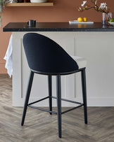 A sleek, modern bar stool with a two-tone upholstered seat, black metal legs, and a curved backrest, perfect for stylish interiors.