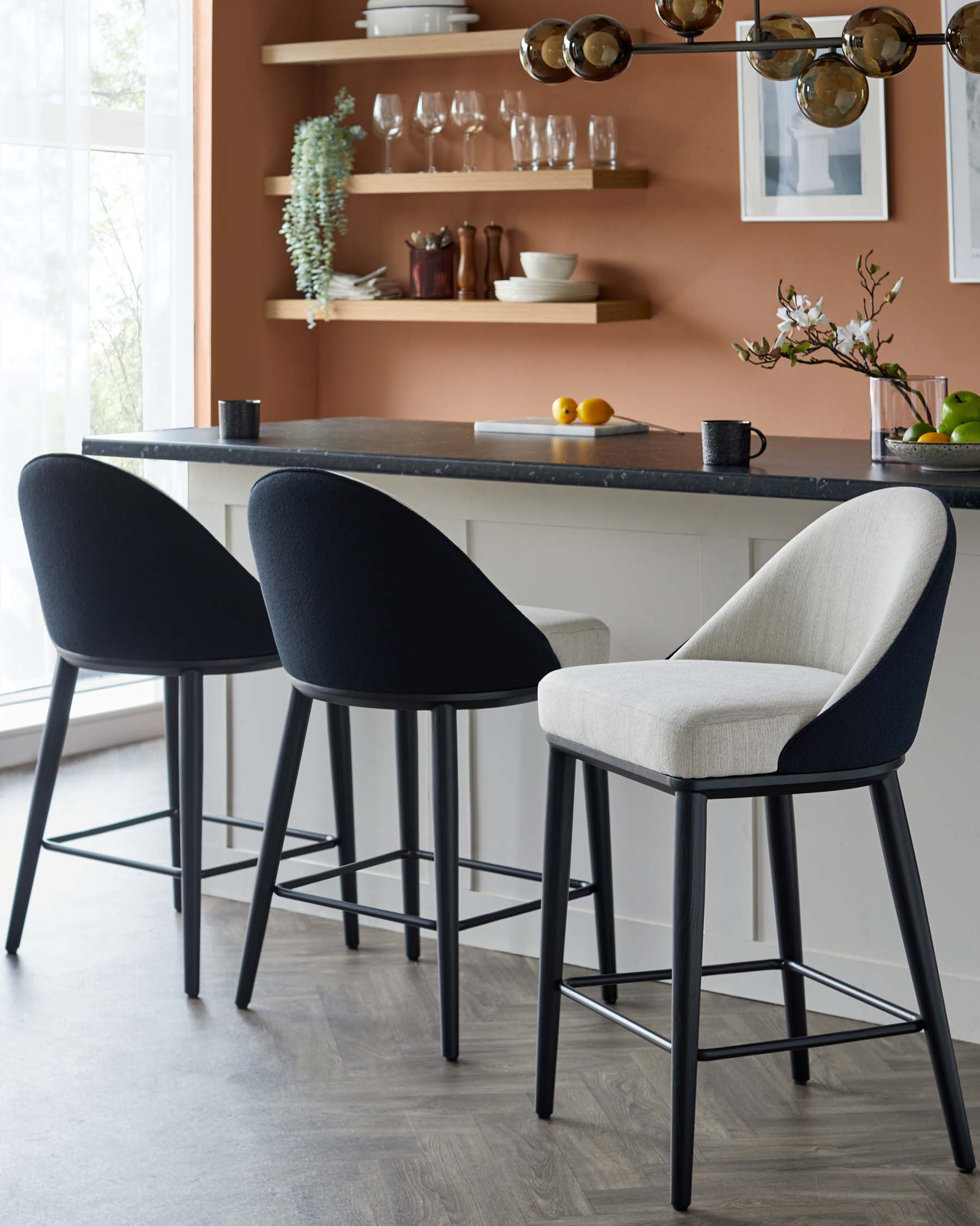 Three stylish bar stools feature a mix of black and light gray upholstery, paired with sleek black legs and a modern design.