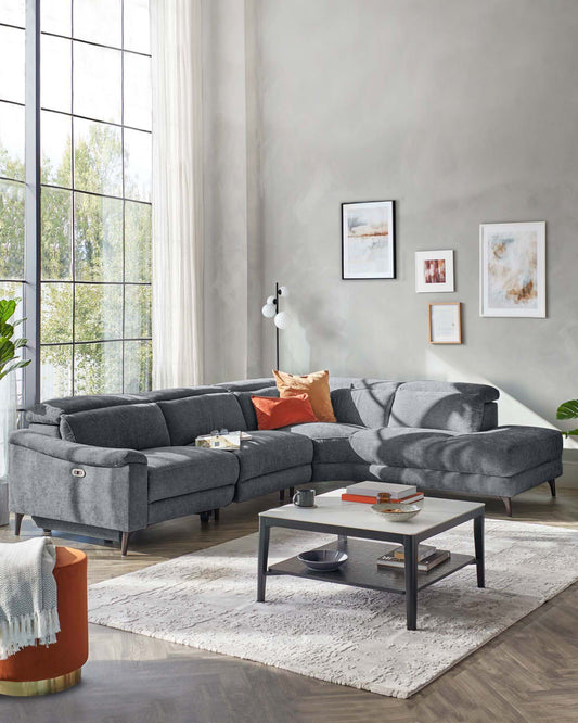 Modern gray sectional sofa with colorful cushions, a minimalist coffee table, and an accent rug, all in a bright, airy setting.