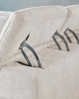 Close-up of a beige fabric sofa featuring reclining mechanisms with sleek metal levers, highlighting its textured upholstery and plush cushioning.