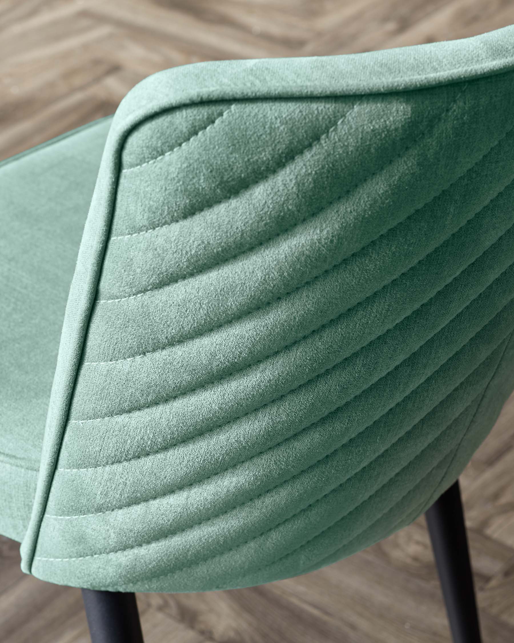 Stylish mint green chair featuring a quilted backrest and sleek black legs, perfect for modern decor.