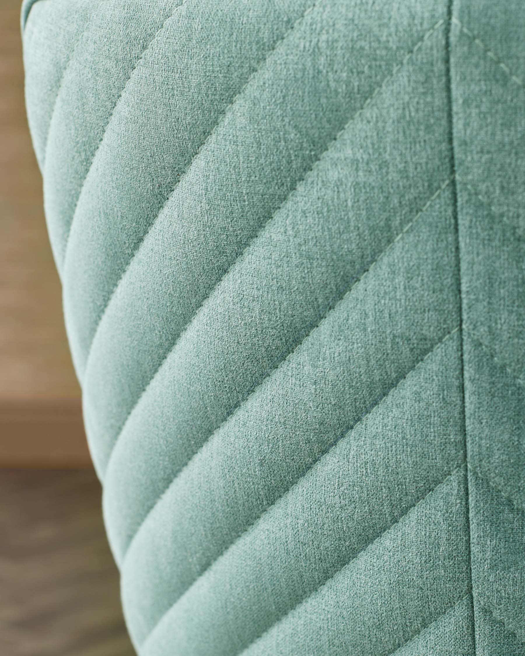 Textured mint-green upholstery featuring a diagonal quilted pattern, ideal for adding a pop of color to any space.