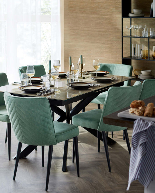 A modern dining table with a glass top and black base, surrounded by upholstered mint green chairs, elegantly set for a meal.