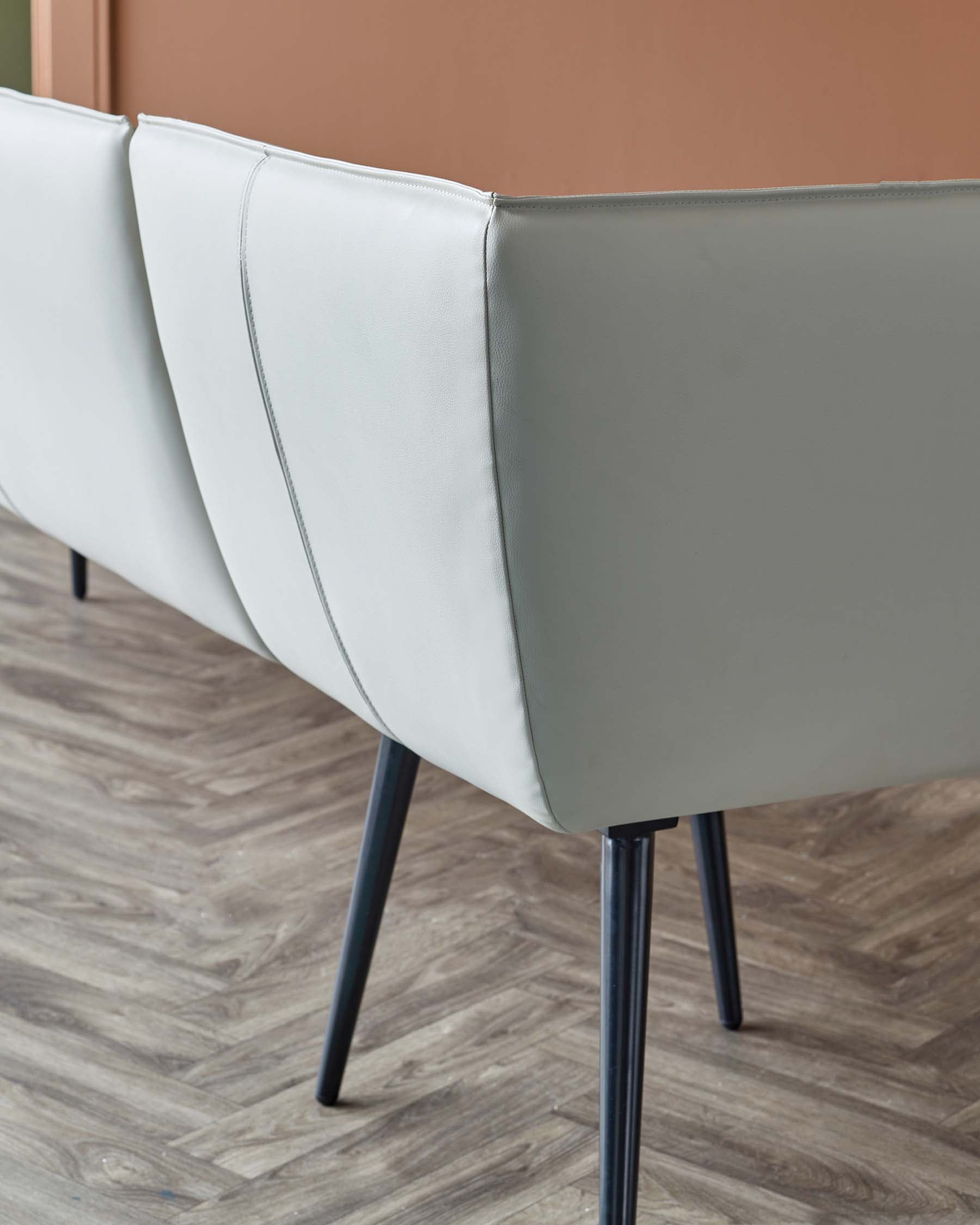 A stylish, light gray upholstered chair featuring sleek, black legs, perfect for modern interiors.