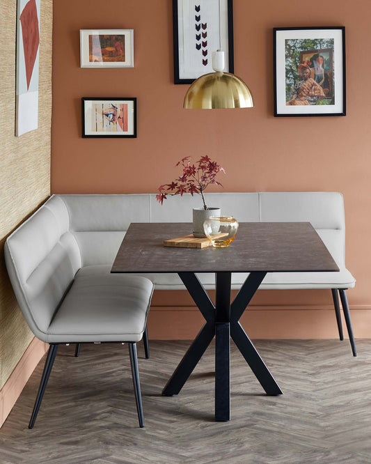 Modern dining setup featuring a sleek rectangular table with an X-base, paired with a minimalist gray bench and decorative accents.