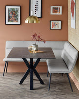 Modern dining set featuring a square table with a dark top and black metal base, paired with a sleek gray upholstered bench.