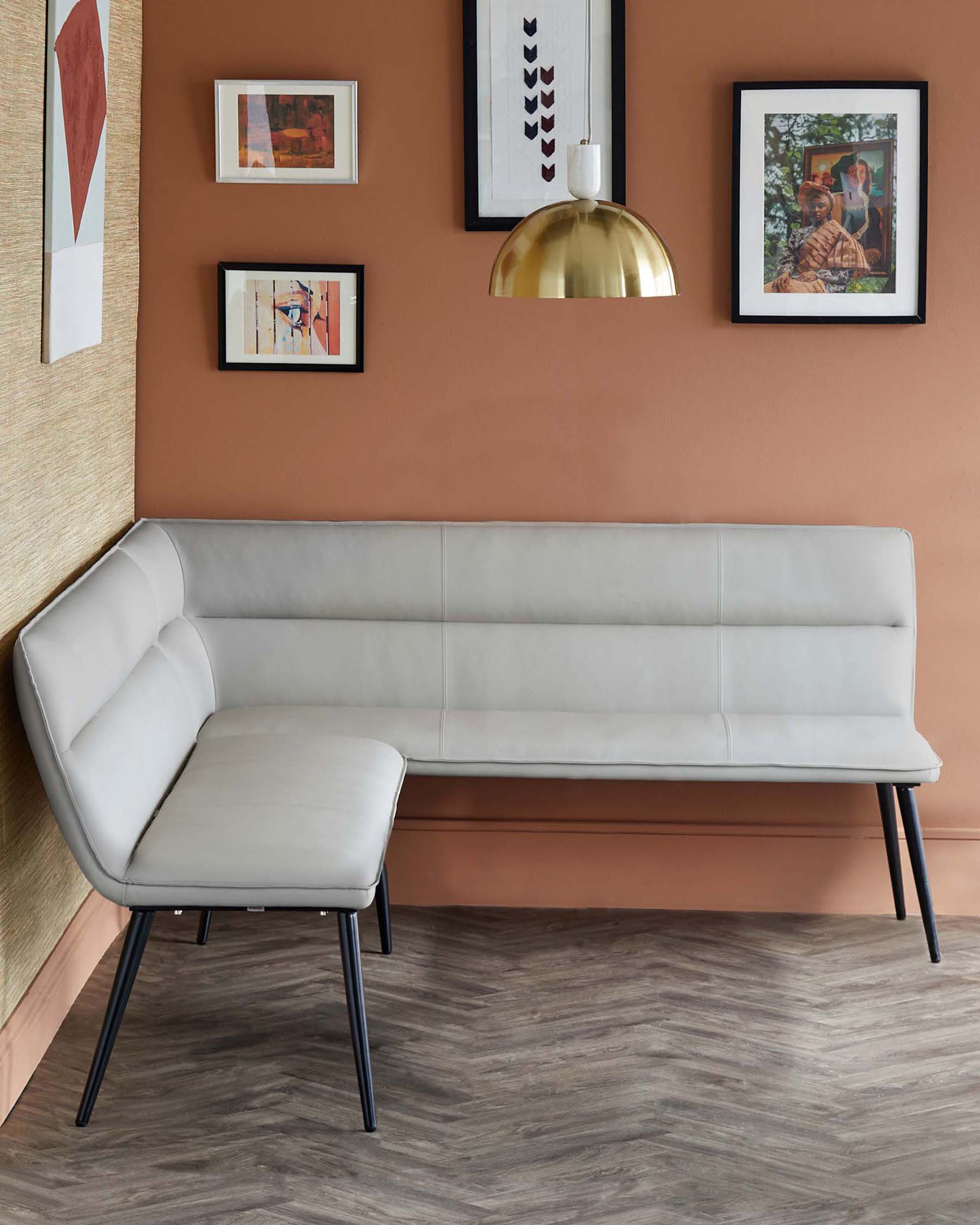 Modern light gray upholstered bench with sleek black legs, designed for casual seating, paired with stylish wall art and pendant light.