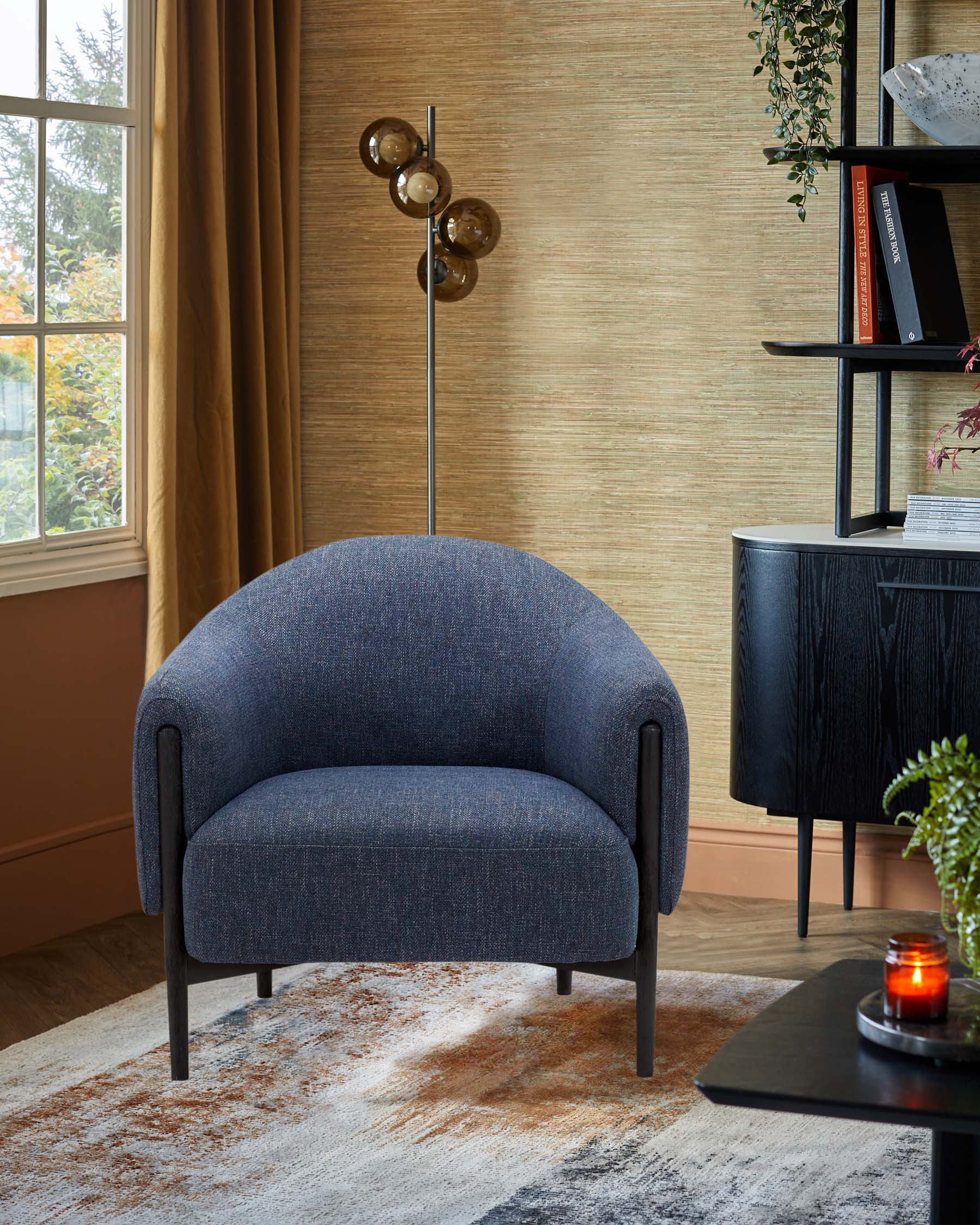 A modern blue upholstered armchair, a sleek floor lamp with round glass shades, and a dark wood side table on a patterned rug.