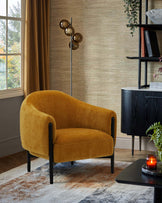 A plush mustard-yellow armchair with black legs, paired with a sleek black side table and a modern floor lamp nearby.