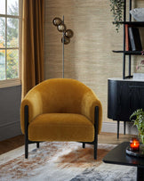 A mustard-yellow upholstered chair with rounded arms, paired with a modern floor lamp and a sleek, dark wood side table.