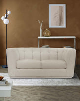 A cozy beige tufted sofa, sleek side table, modern floor lamp, and decorative vases create a stylish living space.