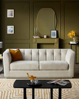 Sleek beige sofa with tufted detailing, black coffee table with decorative items, and a warm-toned area rug in a stylish setting.