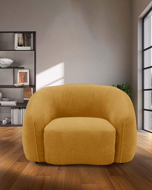 A soft, curvy yellow accent chair with a plush seat, set against a minimalist backdrop of shelves and natural light.