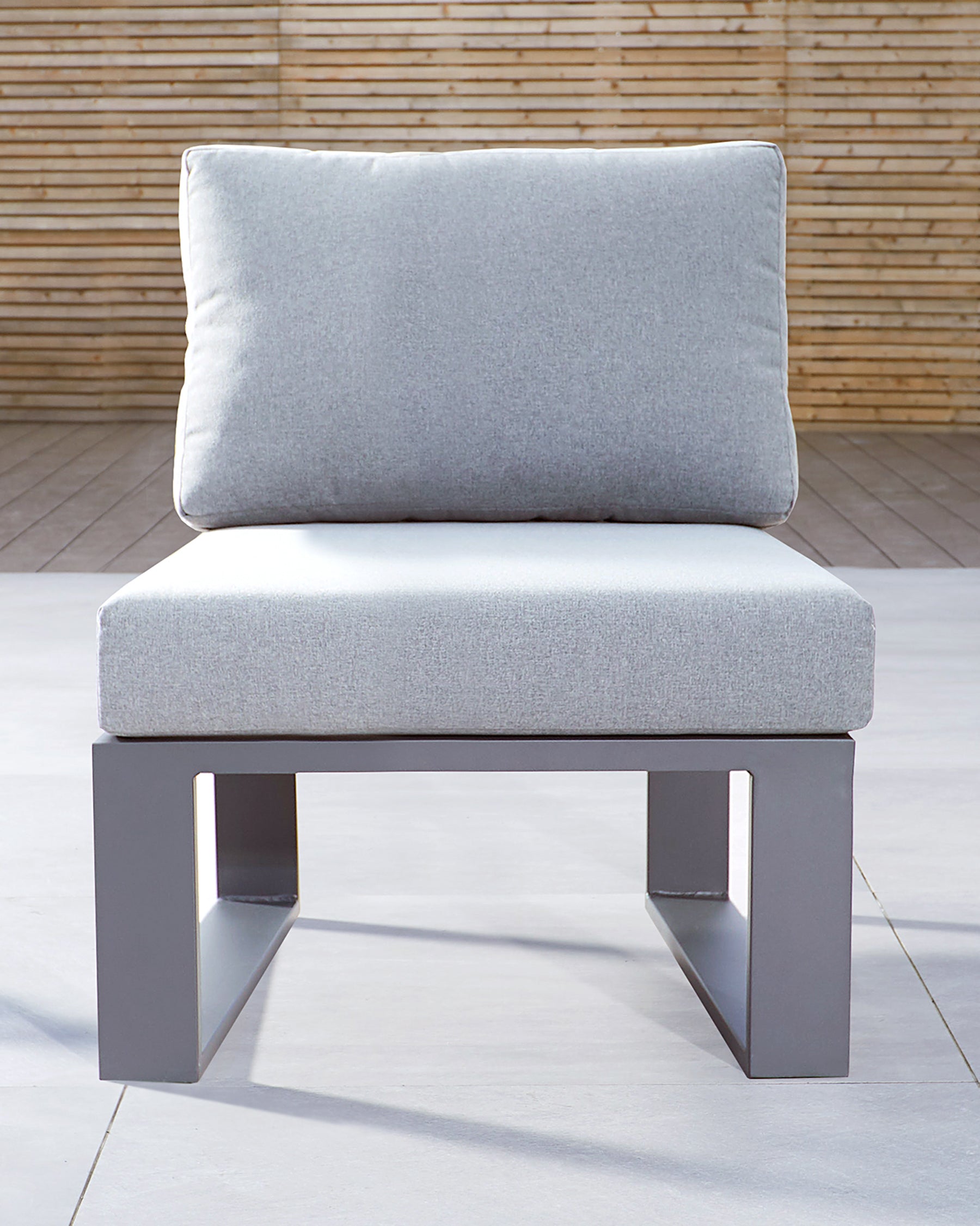 Modern minimalist single-seat lounge chair with a light grey fabric cushion and a single matching fabric backrest pillow, mounted on a sleek metallic grey base with a rectangular silhouette.