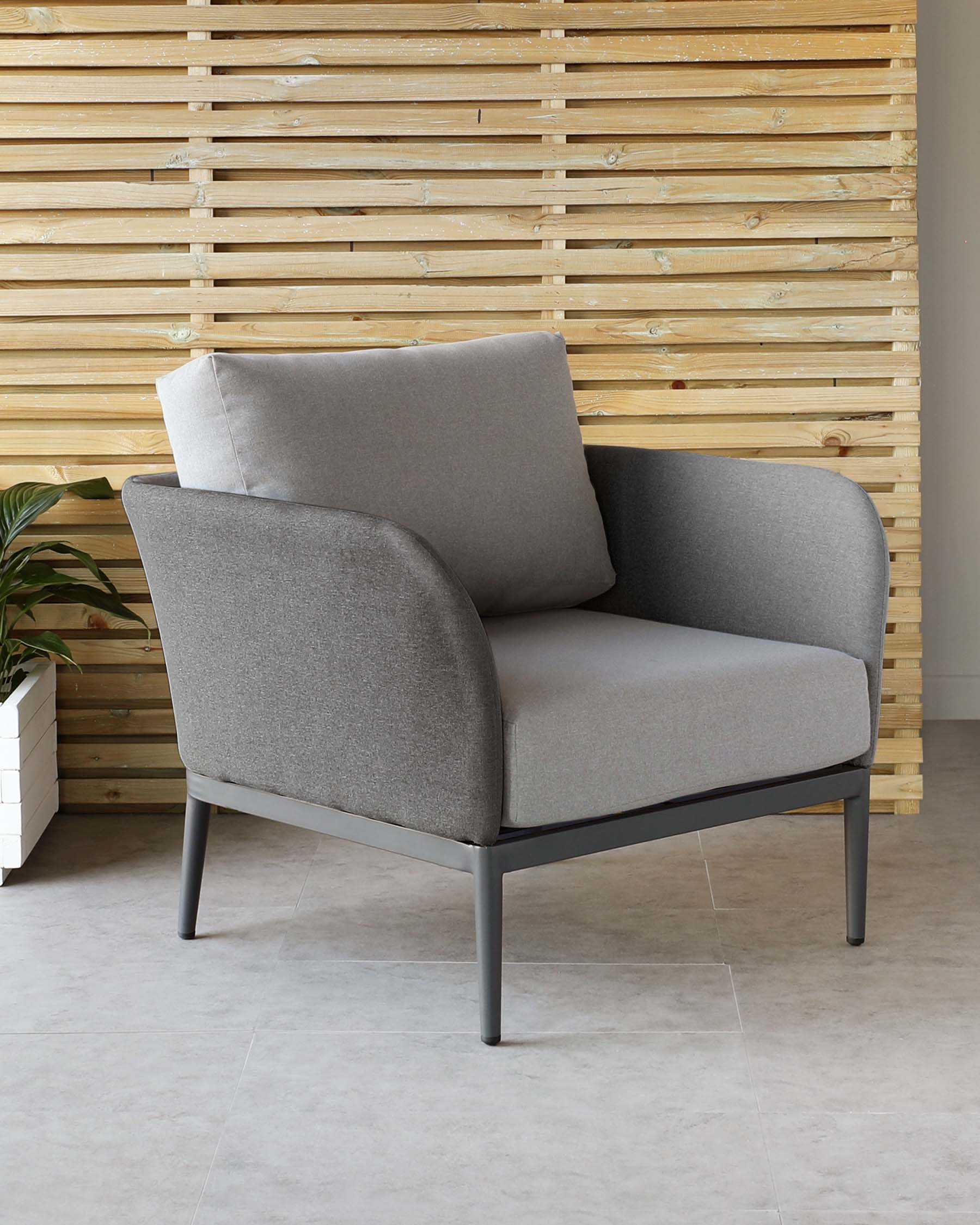 Modern single-seat armchair with grey upholstery and a minimalist black metal frame, set against a wooden slat wall backdrop with a potted plant to the side.