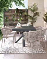 Contemporary outdoor dining set featuring four stylish light grey, woven rope chairs with metal legs and cushioned seats, paired with a minimalist black rectangular table with a solid top and angular metal legs. The set is arranged on a geometric-patterned outdoor rug, complementing an elegant patio setting.