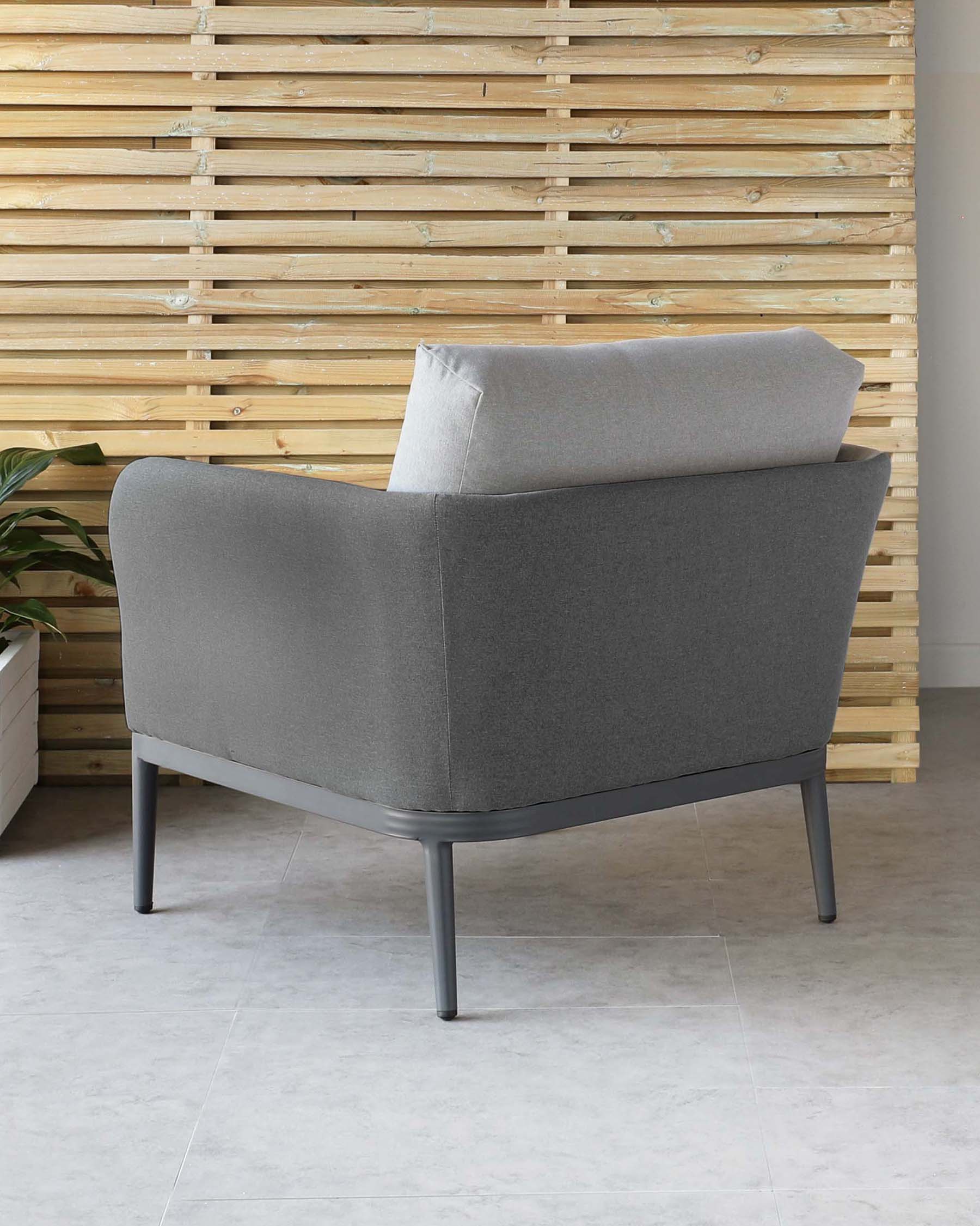 A contemporary style armchair with a heathered grey fabric upholstery. It features a curved backrest, a single cushion for the seat, and a slightly angled side profile. The chair has a low profile with minimalist black metal legs that offer a sleek contrast to the light grey fabric.