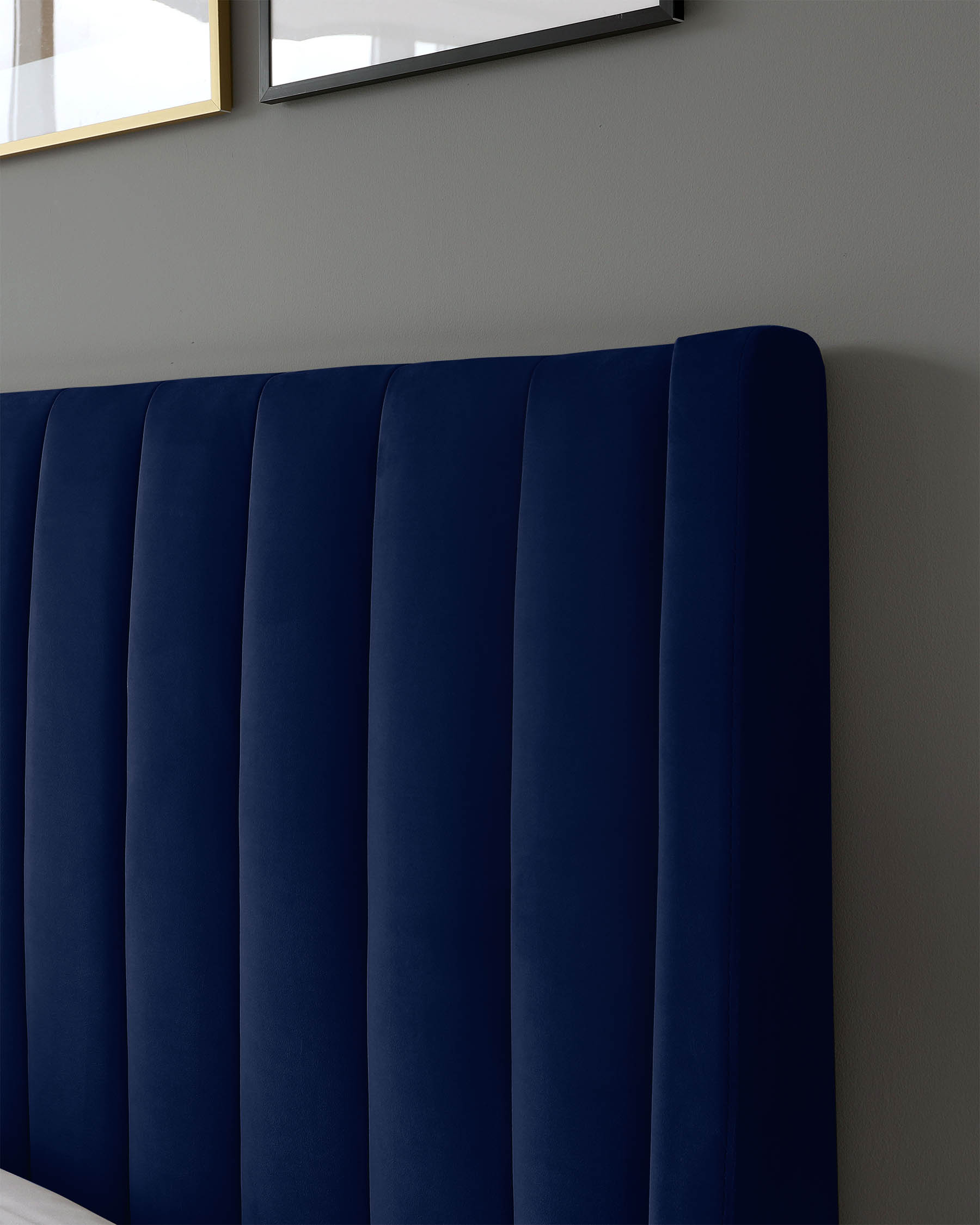 Navy blue upholstered headboard with vertical channeling, enhancing modern elegance against a soft gray wall backdrop.