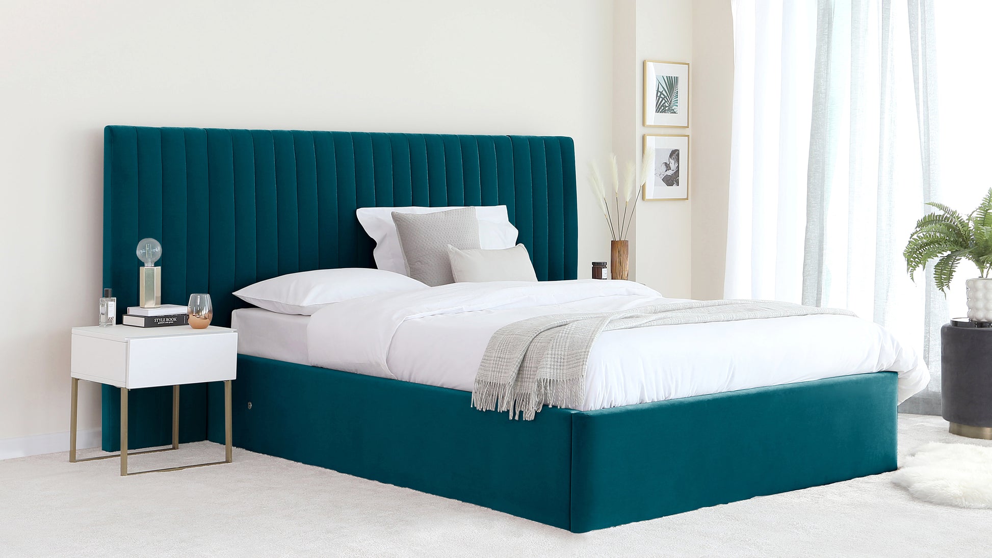 Elegant emerald green upholstered queen-size bed with a tall, vertical channel-tufted headboard, flanked by a modern white nightstand with gold metal legs.