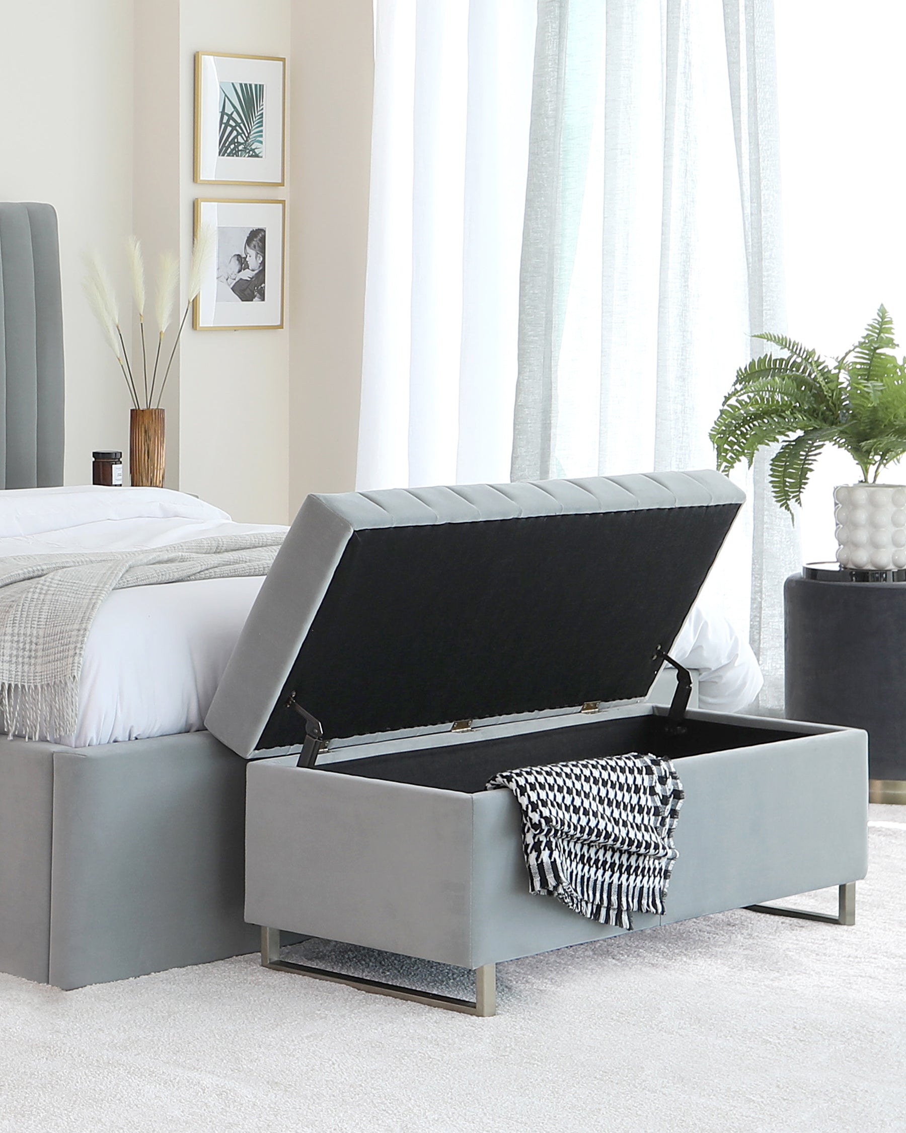 Contemporary grey upholstered bed frame with an open storage bench at the footboard, featuring a tufted lift-top accentuated with metallic legs.