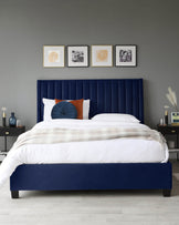 Navy upholstered bed with vertical tufting, decorative pillows, white bedding, and modern side tables with lamps and decor.