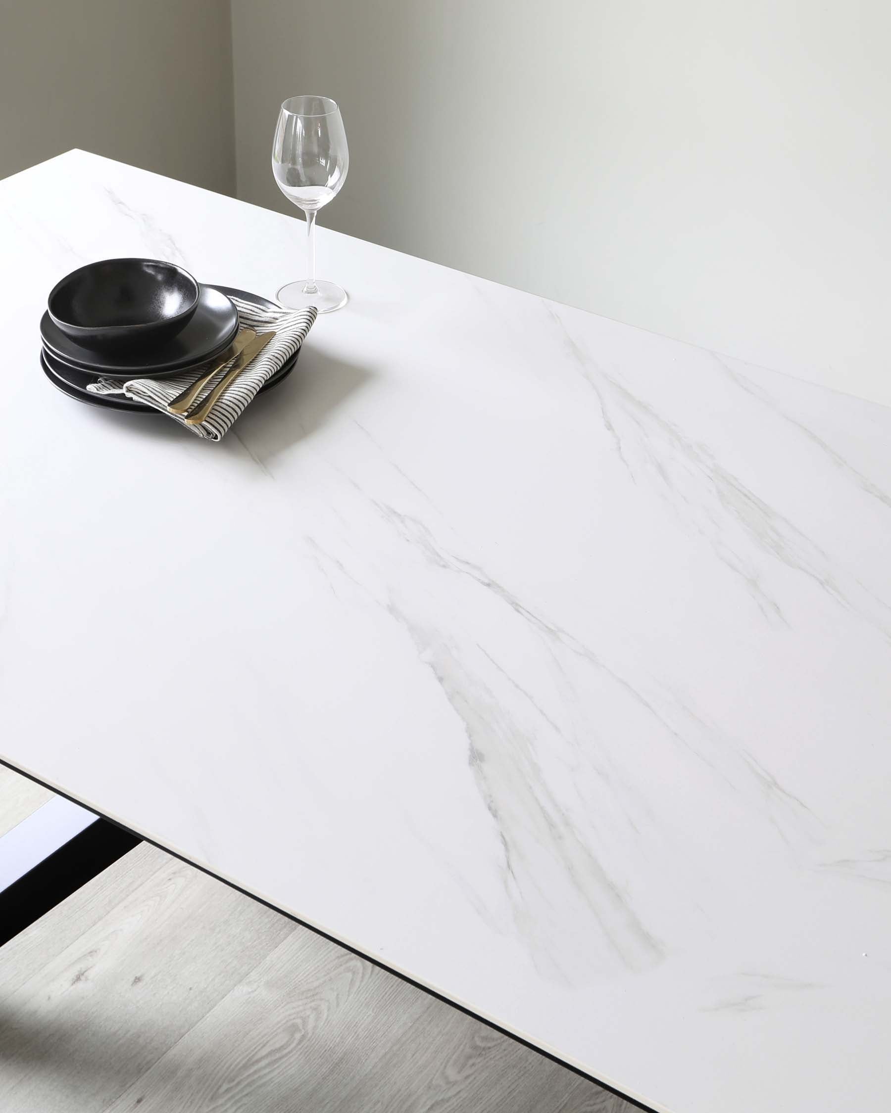 Modern minimalist dining table with a white marble finish on top and sleek metal legs.