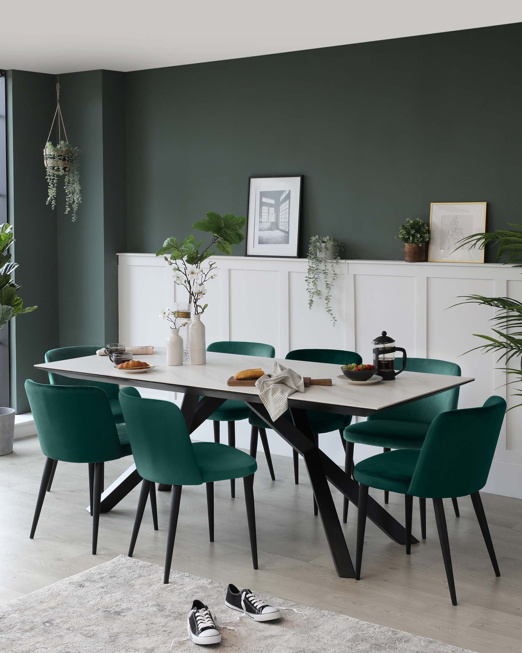 Modern dining room furniture featuring a rectangular table with a light wood top and black angular legs, accompanied by six plush, teal upholstered chairs with black wooden legs.