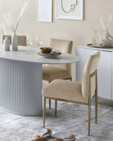 Modern dining room furniture set featuring a round, white table with a fluted pedestal base and two minimalist, upholstered dining chairs with sleek metallic legs. The chairs have a soft beige fabric, providing an elegant contrast to the clean lines of the table.