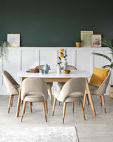 Round dining table with a light wood finish and angled legs, accompanied by four mid-century modern style chairs with curved backrests and beige upholstery, set on a light hardwood floor with a white rug underneath.