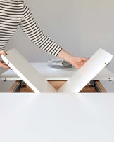 Modern white table with innovative lift-up mechanism, showcasing versatility and functionality in a minimalist design.