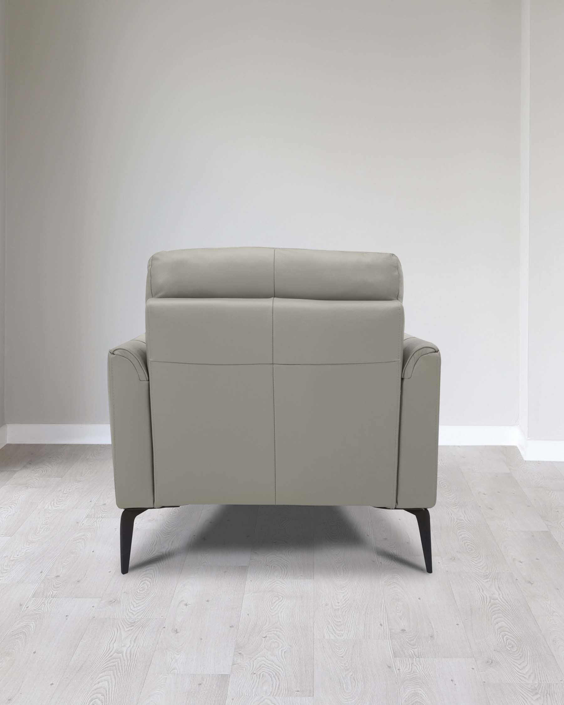 Modern light grey leather loveseat with a minimalist design featuring clean lines, a smooth finish, and tapered dark wooden legs, displayed in a room with light hardwood flooring and neutral walls.