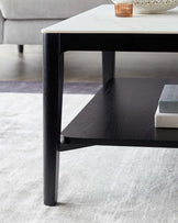 Elegant two-tiered rectangular coffee table with a sleek black wooden frame and a white marble tabletop, showcasing modern design suitable for contemporary living spaces.