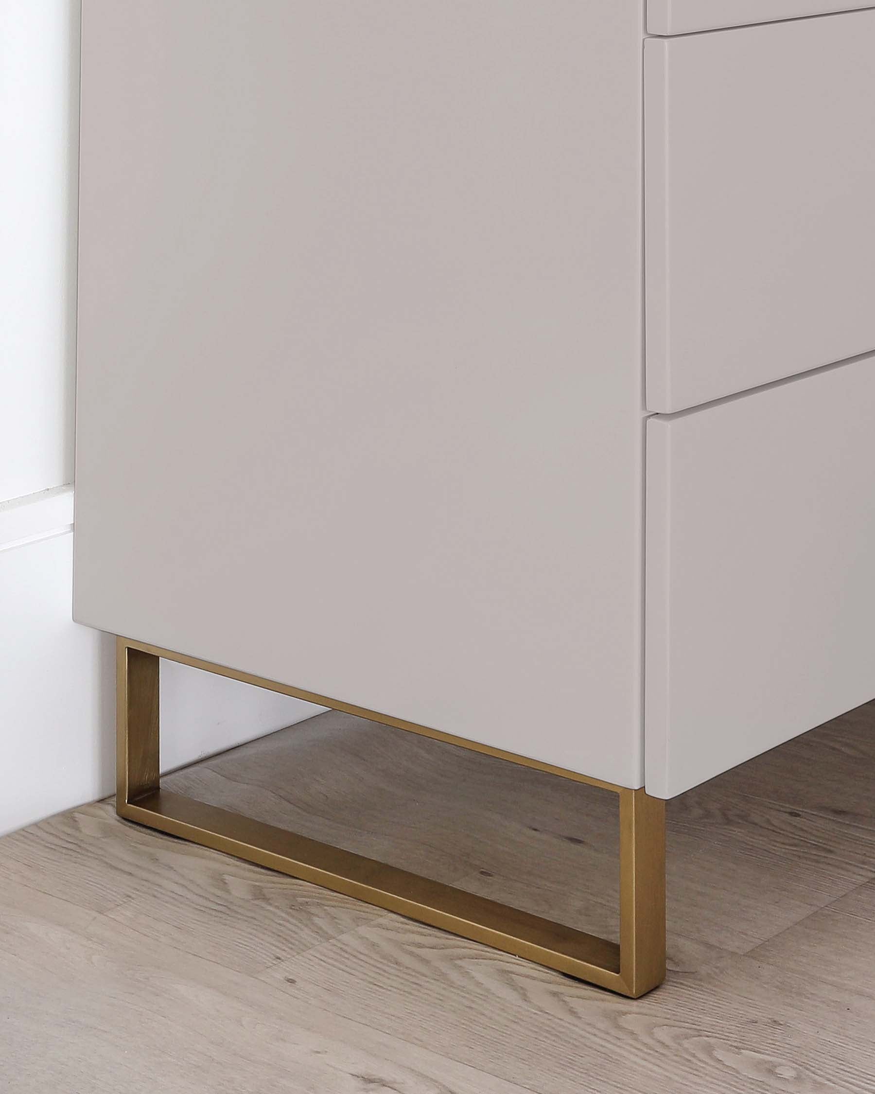 Contemporary light grey cabinet featuring clean lines with a smooth finish, and a sleek metallic gold base that provides a touch of luxury and visual elevation.