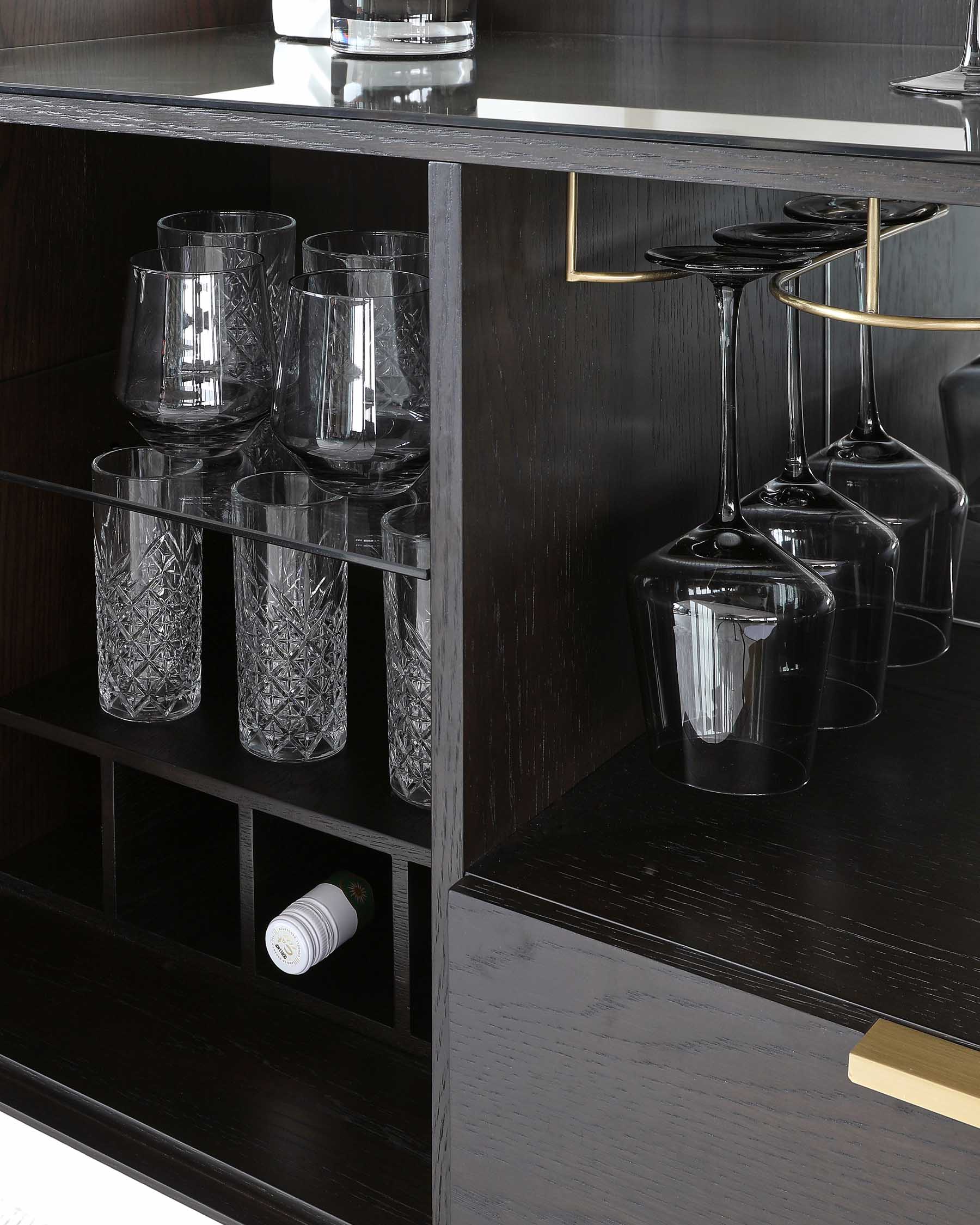 A modern, dark wood bar cabinet with a sleek design and gold-toned handles, featuring a built-in wine glass rack and multiple shelves with various patterned glassware and a wine bottle.