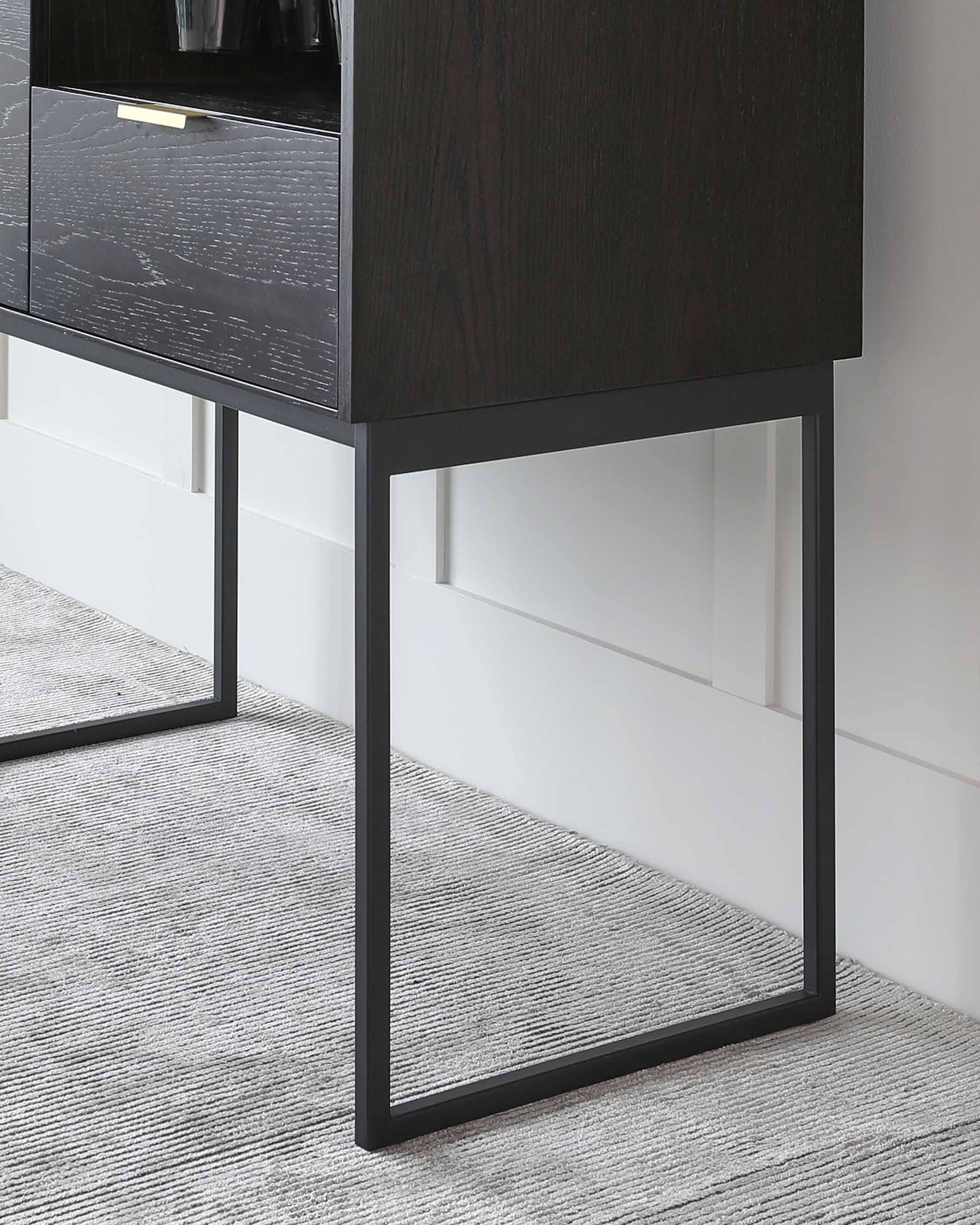 Modern dark wood nightstand with sleek metal handles and raised on a minimalist black metal frame, set against a white wall and on a grey textured rug.