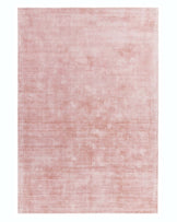 Large, blush pink area rug with a subtle, distressed texture, providing a contemporary and minimalist aesthetic.