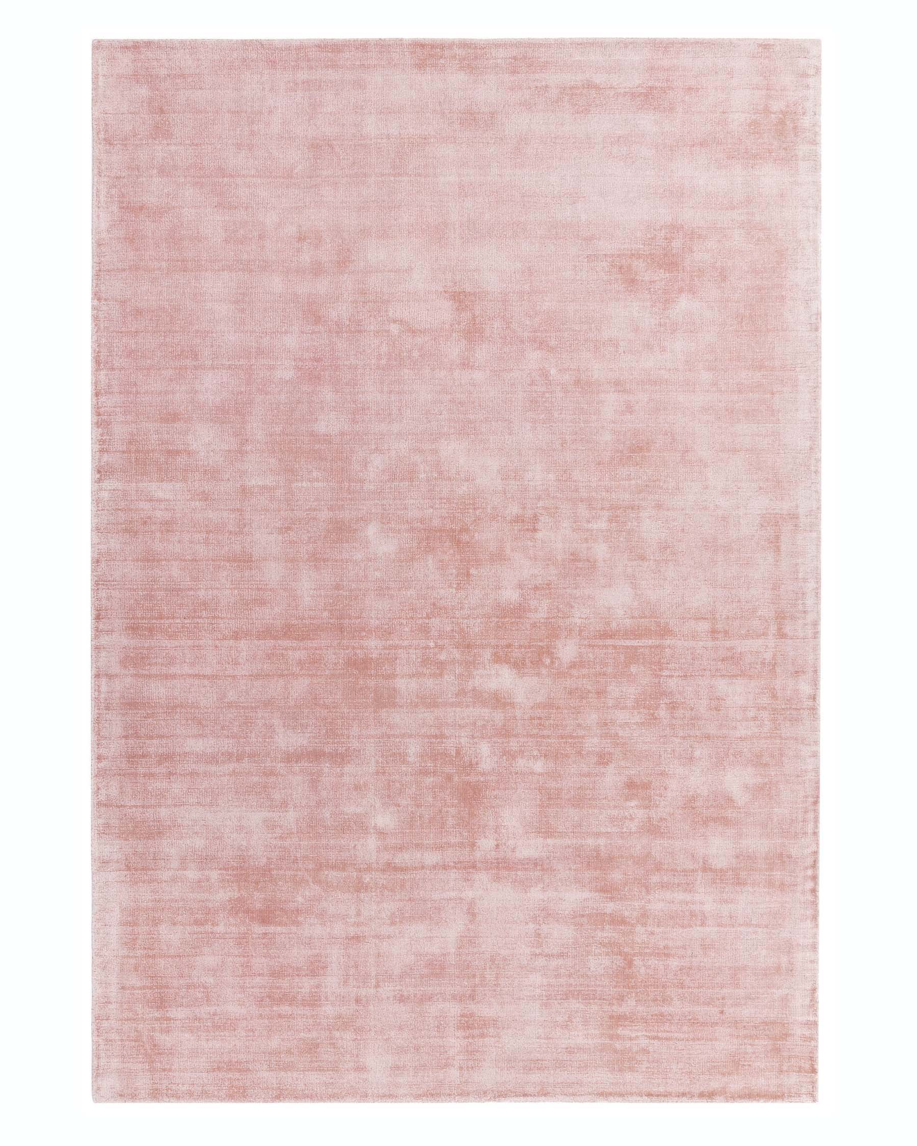 Large, blush pink area rug with a subtle, distressed texture, providing a contemporary and minimalist aesthetic.