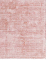 Soft blush pink area rug with a subtle distressed texture effect.