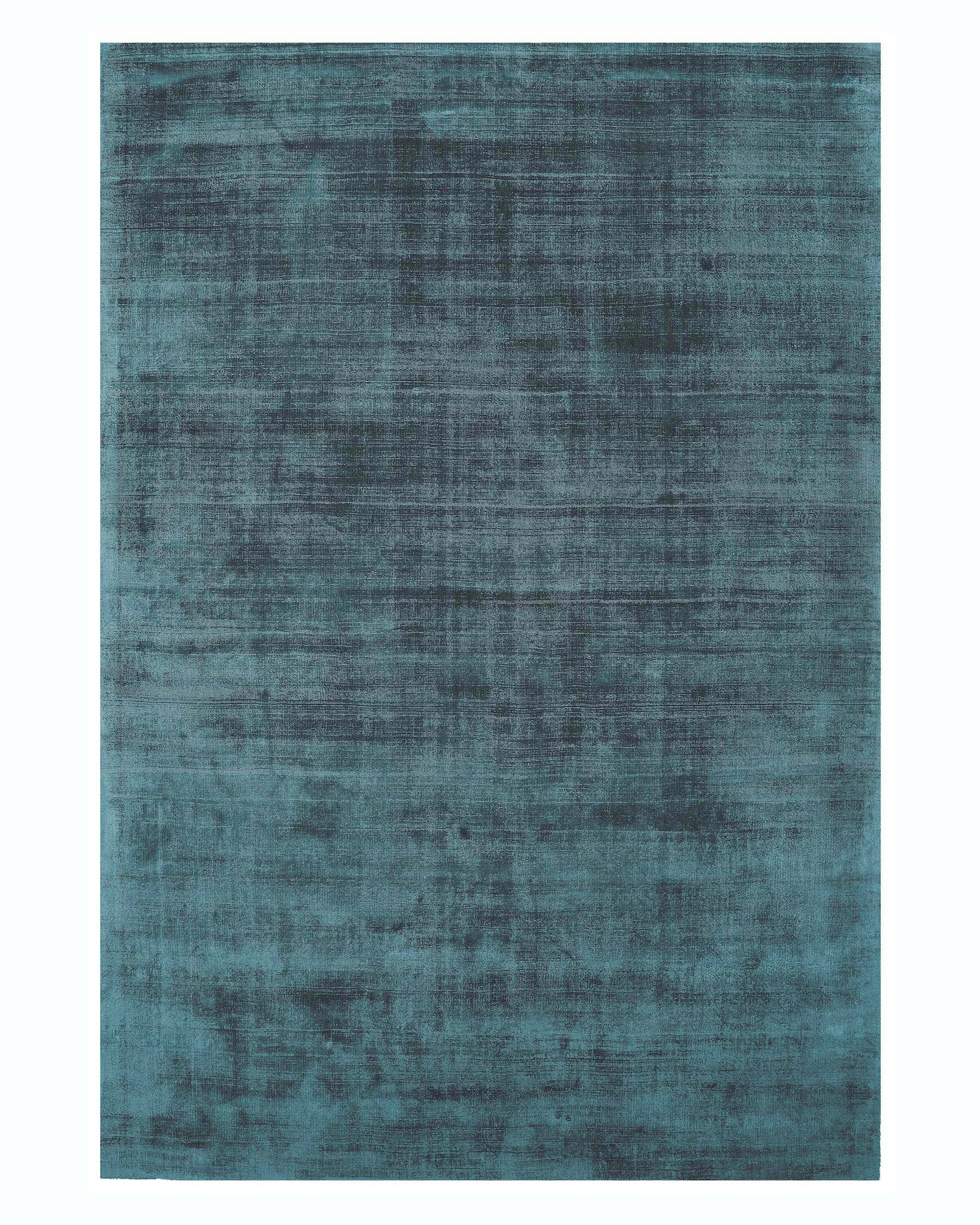 The image displays a luxurious, deep blue area rug with a subtle, distressed texture, offering a contemporary and sophisticated look suitable for modern interiors.