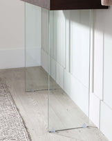 A minimalist, full-length floor mirror with a slender, unframed design, featuring transparent glass with a slight tint for clarity, and supported by small, discreet, clear stands for stability.