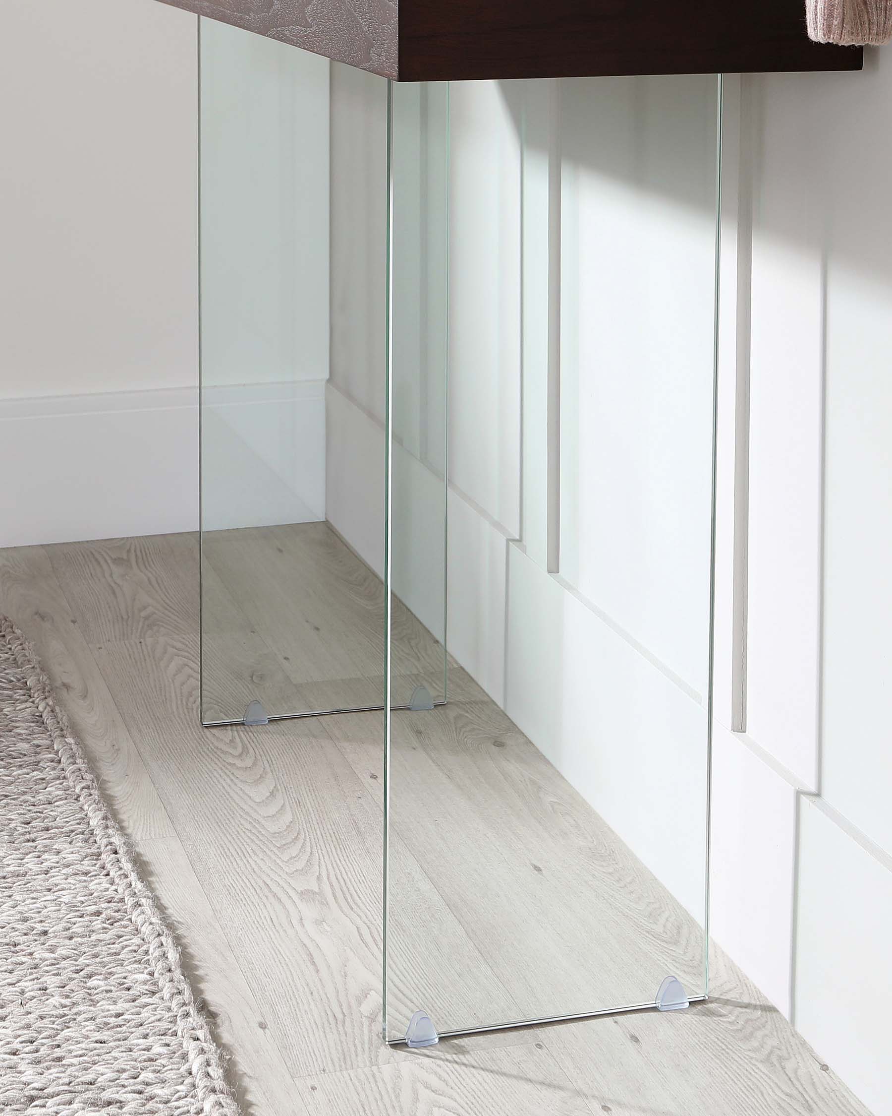 A minimalist, full-length floor mirror with a slender, unframed design, featuring transparent glass with a slight tint for clarity, and supported by small, discreet, clear stands for stability.