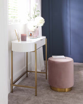 Elegant half-moon console table with a white tabletop and gold-finished metal legs, accompanied by a round, blush pink velvet ottoman with a gold base trim.