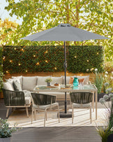 Stylish outdoor seating with a large umbrella, a glass-top dining table, and green accent chairs, set in a lush garden space.