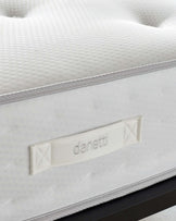 Close-up of a textured white mattress with a detailed edge stitching and a branded label that reads "Danetti."