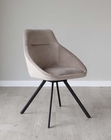 Modern taupe upholstered dining chair with a curved backrest and padded seat, featuring angular black metal legs.