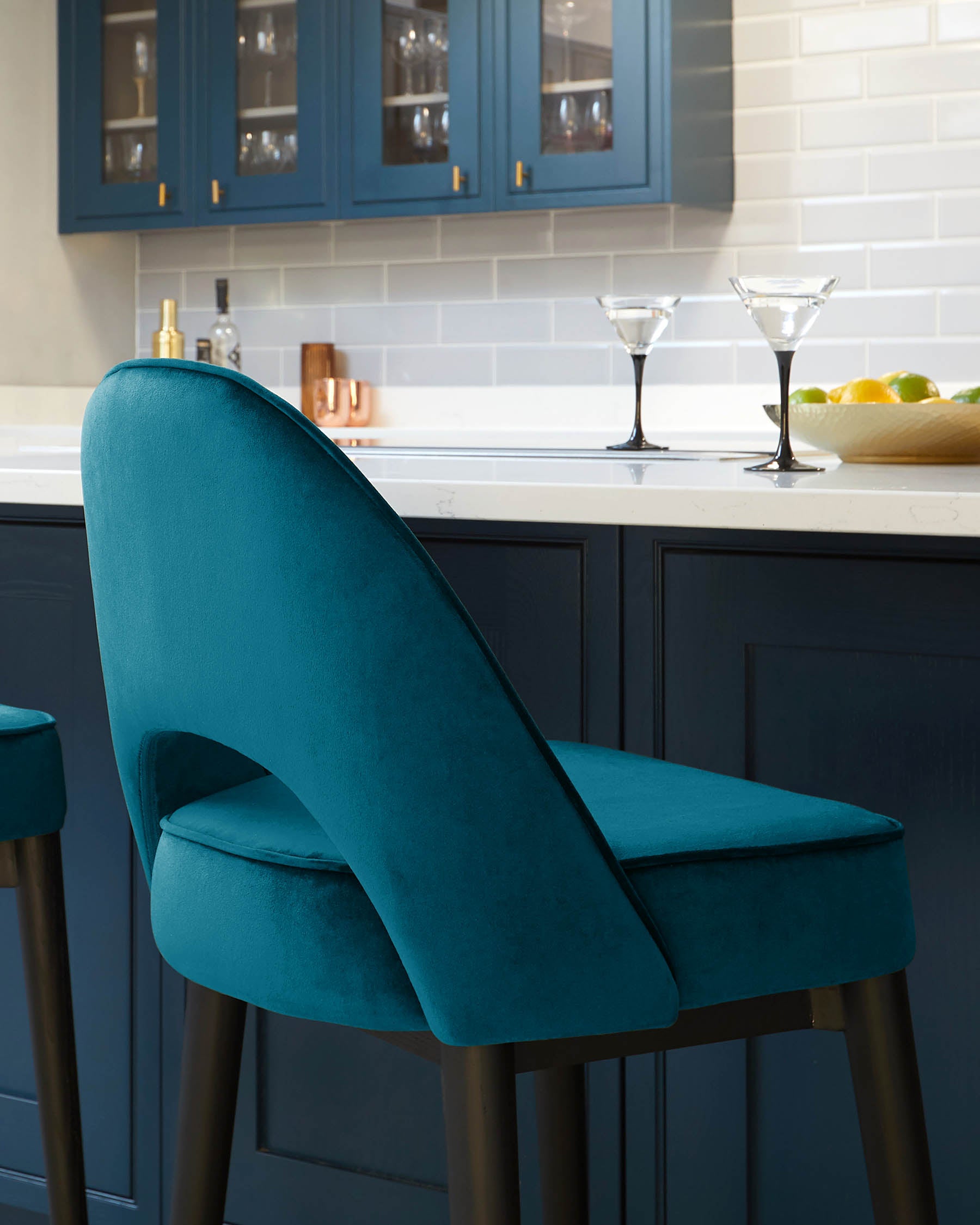 Elegant teal upholstered bar chair with a curved backrest and comfortable seat, featuring sleek dark wooden legs.