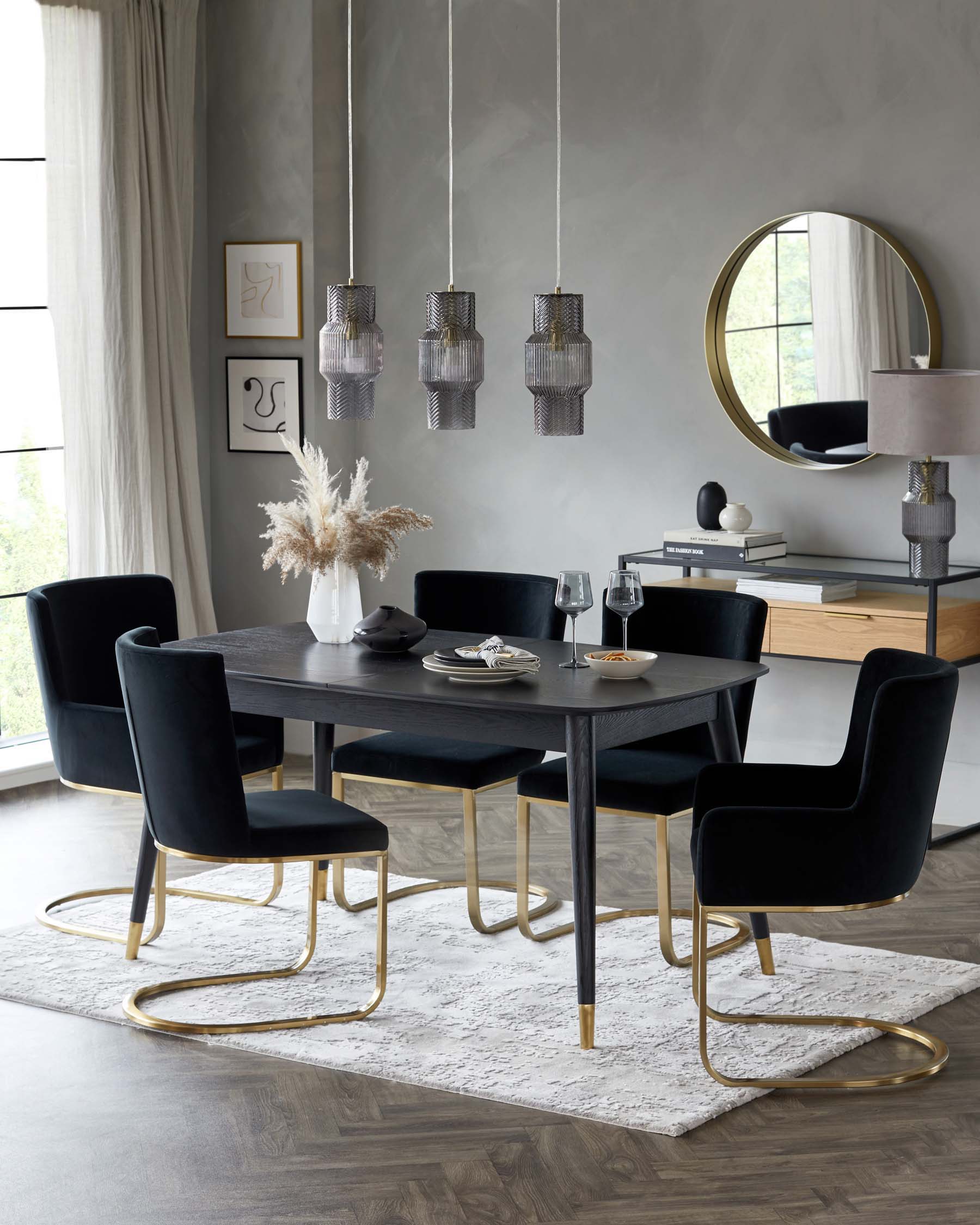 Elegant dining room set with a dark wood rectangular table and four plush velvet chairs, each with a unique gold metal base. A dark wood sideboard complements the table, paired with a modern lamp and a round mirror with a gold frame. Above the table, a series of stylish pendant lights with a textured glass design. The set is arranged on a white textured area rug.