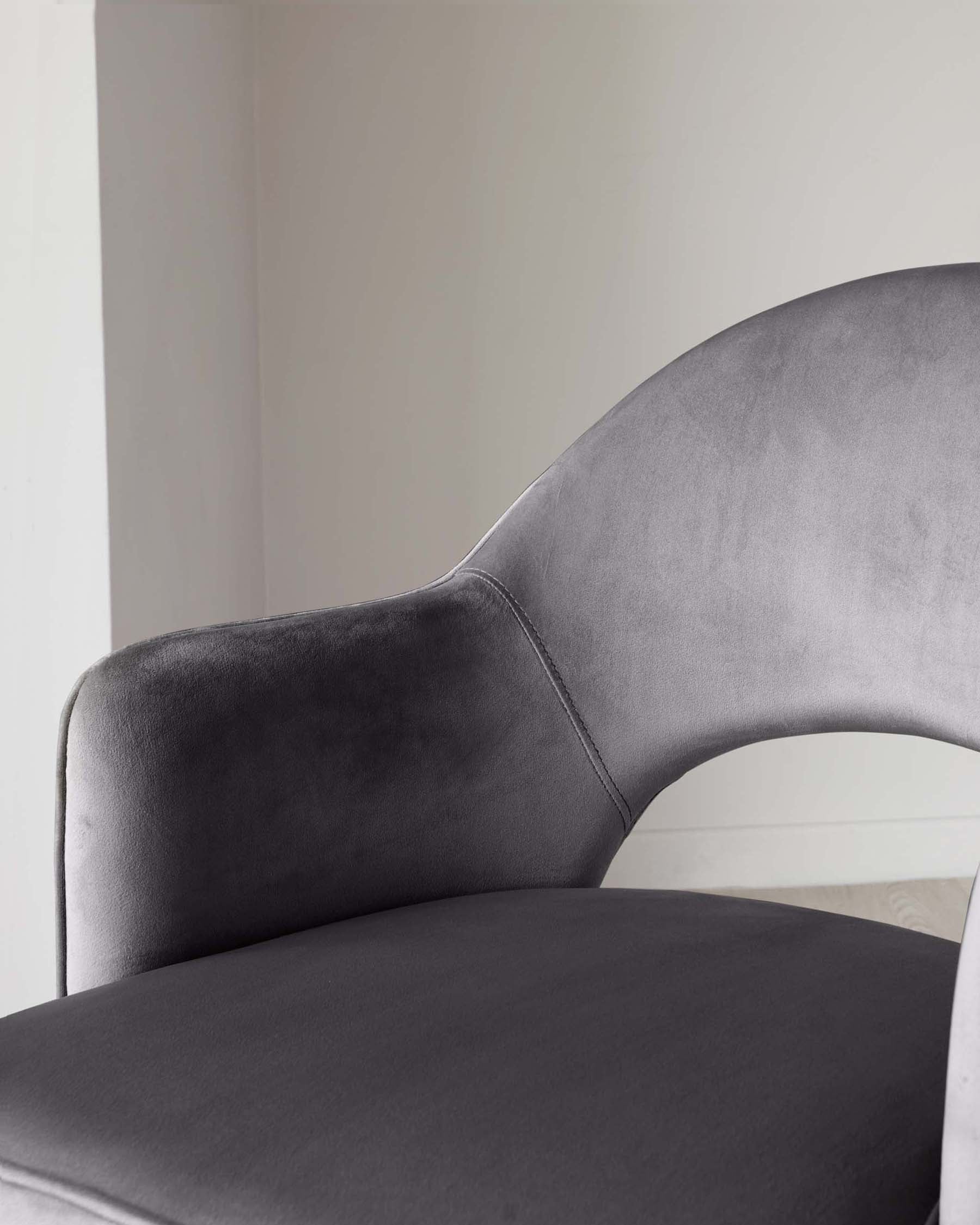 Elegant grey velvet dining chair with a curved backrest and a comfortable, wide seat pad.