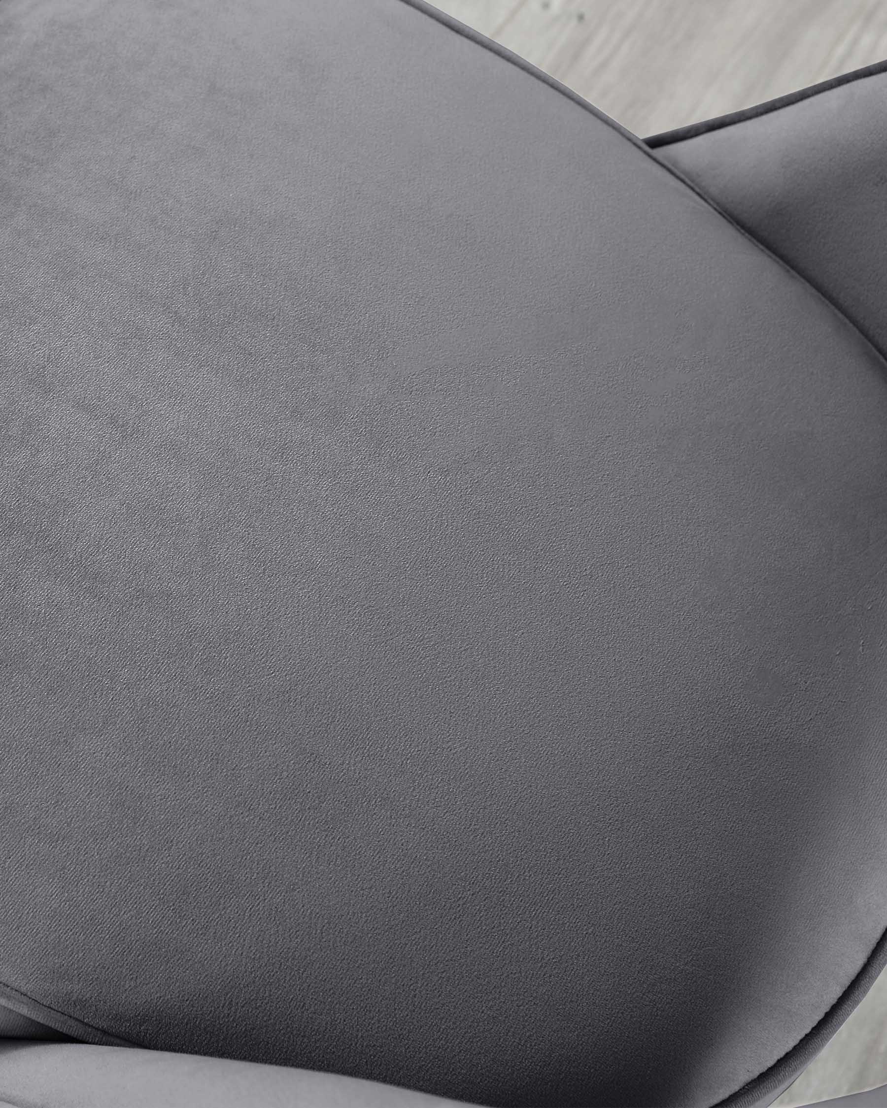 Close-up of a charcoal grey upholstered chair with a smooth fabric texture and subtle stitching details, highlighting the contoured design of the seat.