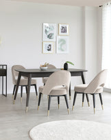 Modern dining room setup featuring an elegant rectangular dark wood table with slender legs capped by brass feet, accompanied by four plush velvet-upholstered chairs with curved backs and brass-tipped legs, on a light hardwood floor.